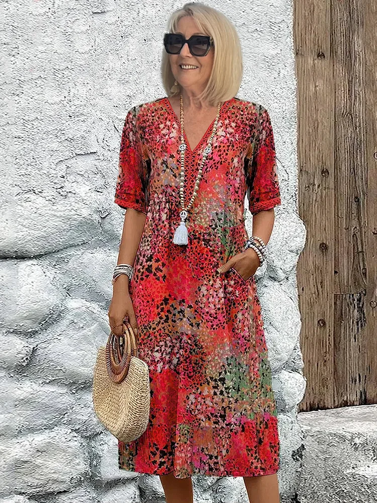 Cecily boho printed V-neck midi dress, close front view against stone wall