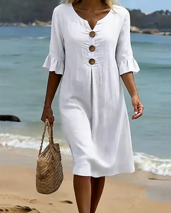 Marigold white midi dress full length with straw bag on beach
